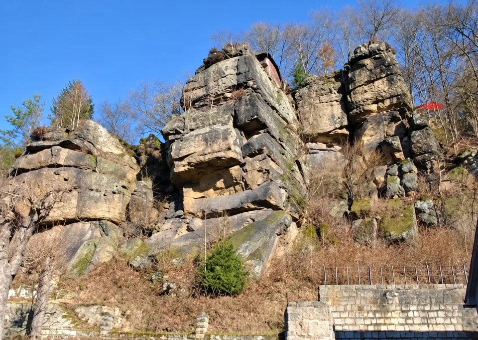 Felsformationen mit Bäumen und einer Steinmauer im Elbsandsteingebirge